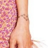 Charisma's tattoo of a rosary circles her left wrist.